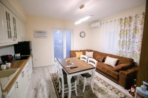 eine Küche und ein Wohnzimmer mit einem Tisch und einem Sofa in der Unterkunft Korca Luxury Apartments & Rooms in Korçë