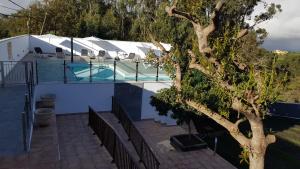 a house with a swimming pool next to a tree at Casitas Gutiérrez in Moya