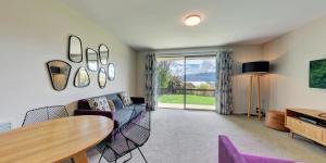 a living room with a couch and a table at Distinction Wanaka Alpine Resort in Wanaka