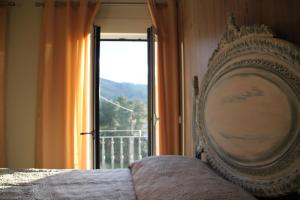 1 cama en un dormitorio con vistas a una ventana en Casas do patrao I en Sabugueiro