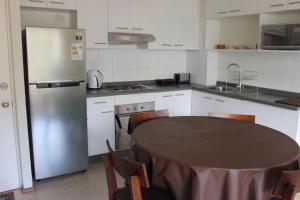 a kitchen with a table and a refrigerator at LAGUNA PAPUDO in Papudo