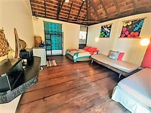 sala de estar con 2 camas y suelo de madera en MOOREA - Local Spirit 4, en Hauru