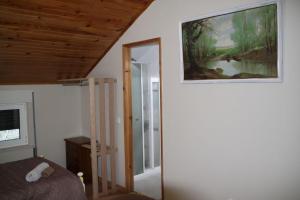 een slaapkamer met een bed en een schilderij aan de muur bij Casas do Patrao II in Sabugueiro