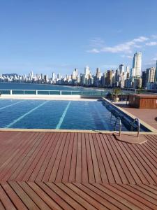 a swimming pool with a city skyline in the background at Flat Prédio Frente MAR in Balneário Camboriú