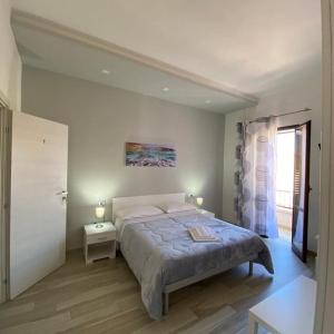 una camera con un grande letto e una finestra di B&B La Casa di Pino a Lampedusa