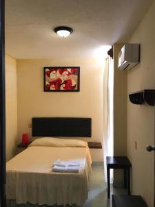 a bedroom with a bed with two towels on it at Hotel Frailes in Arriaga