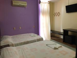 a hotel room with two beds and a window at Hotel Frailes in Arriaga
