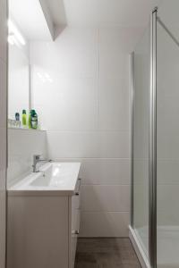 een witte badkamer met een wastafel en een douche bij Feels like Home in Berlijn