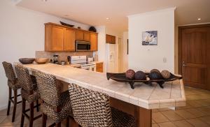 a kitchen with a counter with chairs around it at Ocean View Condo in Los Sueños in Herradura