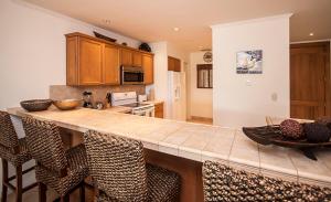 a kitchen with a large counter with chairs around it at Ocean View Condo in Los Sueños in Herradura