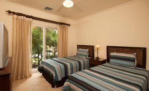 two beds in a room with a window at Ocean View Condo in Los Sueños in Herradura