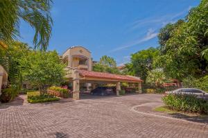 a house with a car parked in front of a driveway at Ocean View Condo in Los Sueños in Herradura