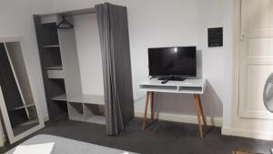 een kamer met een tv op een tafel met een gordijn bij Chambres d'Hotes Centre Ville in Agen