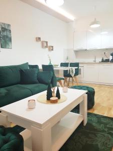 una sala de estar con un sofá y una mesa en Pinevile apartman 4, en Zlatibor
