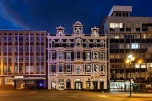 a large white building in a city at night at Fable Dunedin in Dunedin