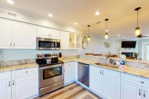 una cucina con armadietti bianchi ed elettrodomestici in acciaio inossidabile di 2436 Stono Watch a Charleston