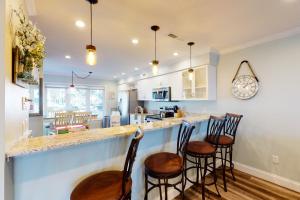 une cuisine avec un bar avec trois tabourets dans l'établissement 2436 Stono Watch, à Charleston