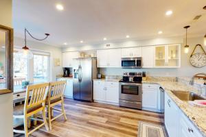 una cucina con armadietti bianchi ed elettrodomestici in acciaio inossidabile di 2436 Stono Watch a Charleston