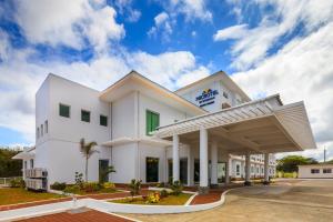 a large white building with a gas station at Microtel by Wyndham South Forbes near Nuvali in Santa Rosa