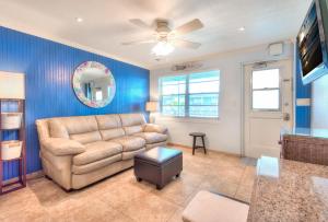a living room with a couch and a ceiling fan at Tropic Terrace #51 - Beachfront Rental condo in St. Pete Beach
