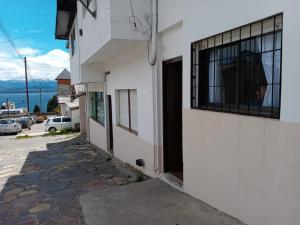 a white building with a window on the side of it at La Casita de Lu in San Carlos de Bariloche