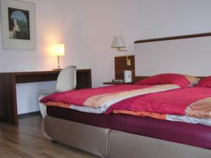 Schlafzimmer mit einem Bett, einem Schreibtisch und einem Stuhl in der Unterkunft Auerbachs Keller in Plauen