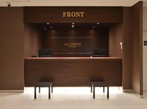 a front counter with two stools in front of a store at Hotel Trend Suzuka in Suzuka