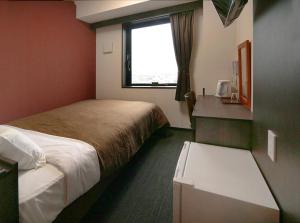 a hotel room with two beds and a window at Hotel Trend Suzuka in Suzuka