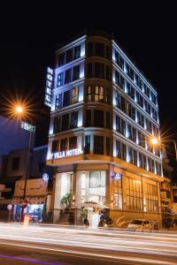 ein beleuchtetes Gebäude mit einem Hotel in der Nacht in der Unterkunft My Villa Hotel - Airport in Ho-Chi-Minh-Stadt