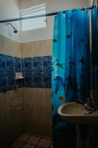 baño con cortina de ducha con pescado en Bungalows Flamingos, en Rincón de Guayabitos