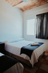 a bedroom with two beds and a window at Bungalows Flamingos in Rincon de Guayabitos +100 photos