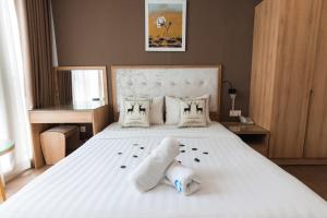 ein Schlafzimmer mit einem großen weißen Bett mit Handtüchern darauf in der Unterkunft My Villa Hotel - Airport in Ho-Chi-Minh-Stadt
