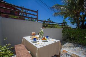 a table with food on it on a patio at Zeisa House in Maresias