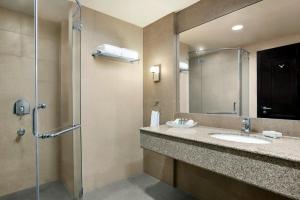 a bathroom with a sink and a shower with a mirror at Ramada by Wyndham Karachi Creek in Karachi