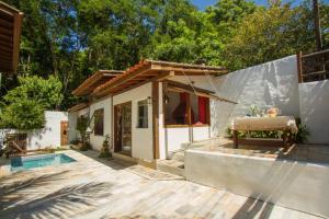 a small house with a pool and a table in it at Zeisa House in Maresias