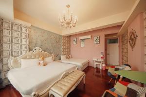 a bedroom with a white bed and a chandelier at 五指山遠百民宿-免費停車場-6人家庭房附電動麻將桌 in Hualien City