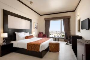 a hotel room with two beds and a television at Ramada by Wyndham Karachi Creek in Karachi