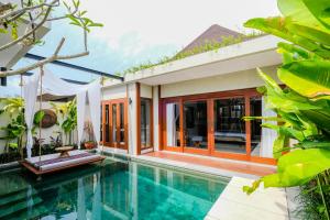 a villa with a swimming pool and a house at Sampatti Villas in Seminyak