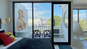 a bedroom with a view of a balcony with a tub at Kunst in Bangkok