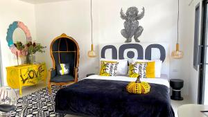 a bedroom with a bed with yellow and black pillows at Kunst in Bangkok