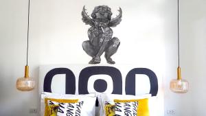 a black demon sitting on top of a bed with pillows at Kunst in Bangkok +80 photos