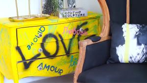 a yellow dresser with graffiti on it next to a chair at Kunst in Bangkok +76 photos