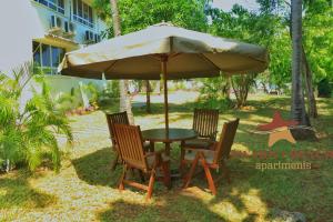 einen Tisch und zwei Stühle unter einem Schirm in der Unterkunft SWAHILI BEACH APARTMENTS in Mombasa