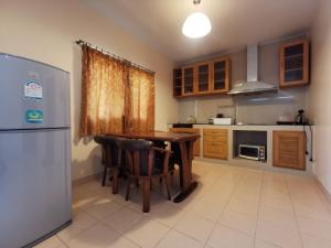 uma cozinha com uma mesa de madeira e um frigorífico em Two Fifty Nine Resort 259 Resort em Si Racha