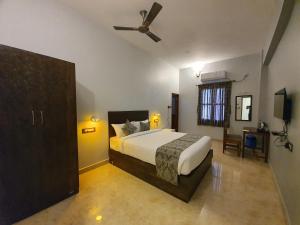 a bedroom with a bed and a ceiling fan at Le Supreme Inn (the lap of luxury) in Puducherry
