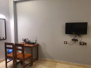 a room with a table and a television on a wall at Le Supreme Inn (the lap of luxury) in Puducherry