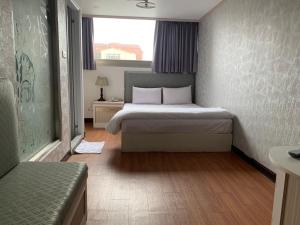 una camera d'albergo con un letto e una finestra di Chrysler Hotel a Taipei