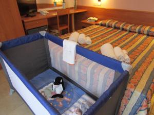 a bed in a hotel room with a baby crib at Hotel Palme Gemelle in Vieste