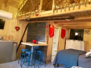 a tiny house with a kitchen and a table and stools at Chambre d'Hôtes Kiki & Coco in Saint-Jean-de-Maurienne