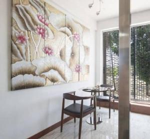 a dining room with a table and chairs and a painting at Avi Fortune Suites - Near Bangalore International Airport in Bangalore